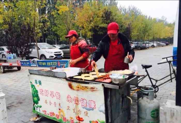 传媒大学附近一个摊位,学生过来买鸡蛋灌饼的特别多,早餐吃一个喝杯