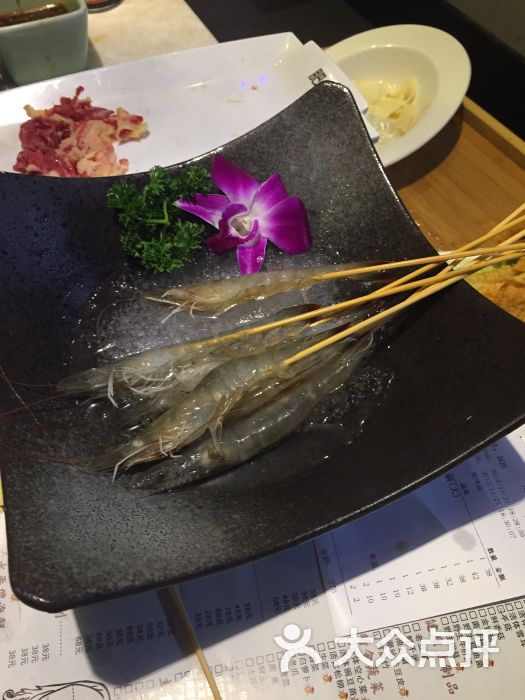 现在的火锅真是可以用八仙过海,各显神通来形容,各有特色,各不相同。这家潮牛,打的是牛肉牌,其实说到底还是火锅。这个每日一宰,新鲜不二的潮牛火锅,牛肉牌打得好不好,我可要好好分析一下了。 【小清新觉得有点问题】 肥聠、吊龙...这些生僻的名字你有听说过吗?我想,来这里吃饭的90%以上的食客从来没有听说过这样的名字吧。 店家确实有考虑到这一点,在餐具下垫着的一张纸上面的一张图上介绍了这些所谓的名字来自于牛的哪个部位,这种介绍给人带来一种高大上的感觉,但是并没有实质性解决我上面提出的问题。顾客在点菜的时候依旧不