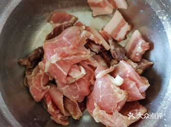 把肉片均匀的铺在盆里，在最上面撒一层蒸肉米粉