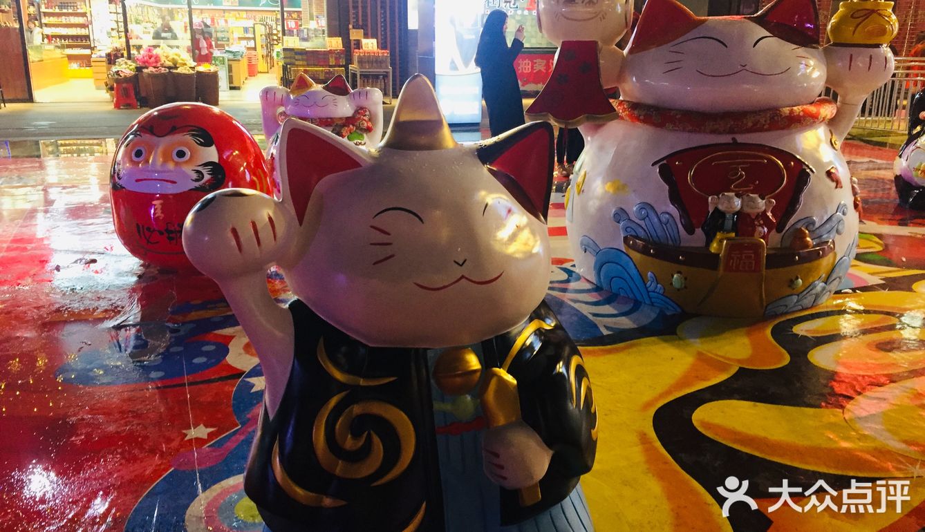 作出向人招来的手势.一般招财猫举左手表示招福