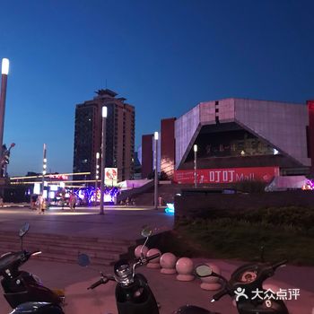夜幕下的贺龙体育馆，在灯光璀璨的叮叮mall广告牌的