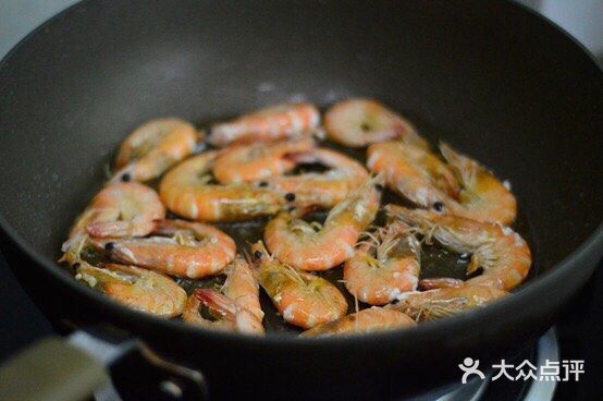 放入虾，用煎炸的方式铺平煎制，一面煎至焦黄后