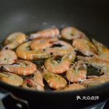 放入虾，用煎炸的方式铺平煎制，一面煎至焦黄后