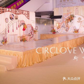 T型舞台，铺上香槟金布料，展示区假山背景，各种鲜花小