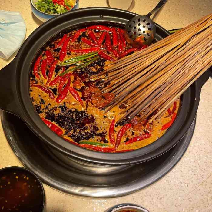 麻渣渣洪七公火锅串串总店-"门匾醒目的印着"洪七公"在桃花的衬托下.