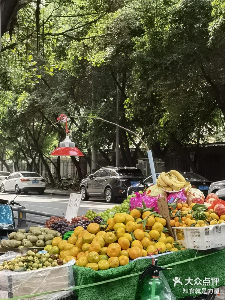 路边卖水果的小推车装满了秋天的红橙黄绿