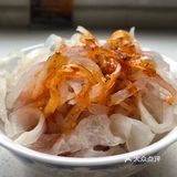 之前还是一片白色的面皮和面筋被染上了辣子油的红色