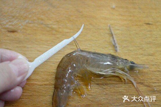 放入虾，用煎炸的方式铺平煎制，一面煎至焦黄后