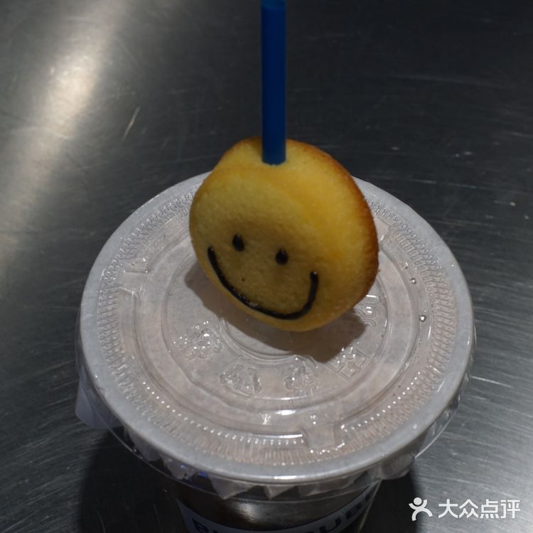 提拉米苏奶茶的吸管上搭配了一个笑脸磅蛋糕