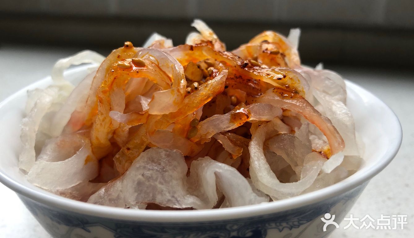 之前还是一片白色的面皮和面筋被染上了辣子油的红色