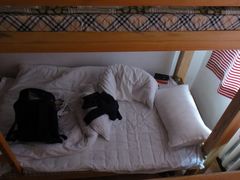 下床是个很有爱的室友，床头那个是圣经好吧-哈尔滨北方国际青年旅舍(中央大街店)