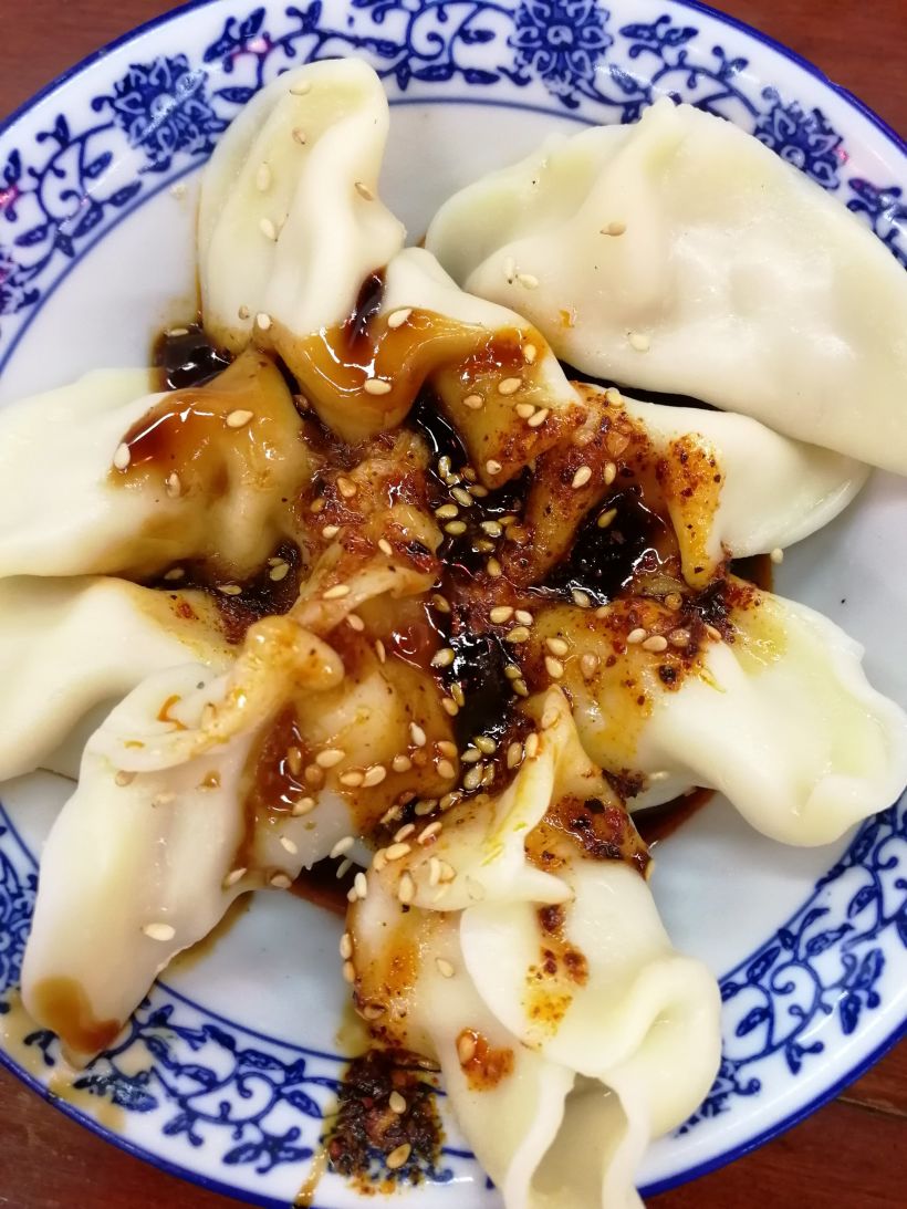 红油水饺:水饺蘸汁红红的,不怎么辣,带些甜味,水饺里面瘦肉多,味道不