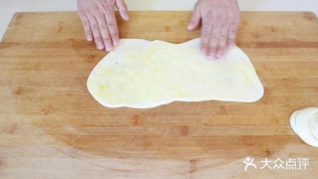 用手将饼皮摊平，盖锅焖上一分钟。一分钟后打开翻面