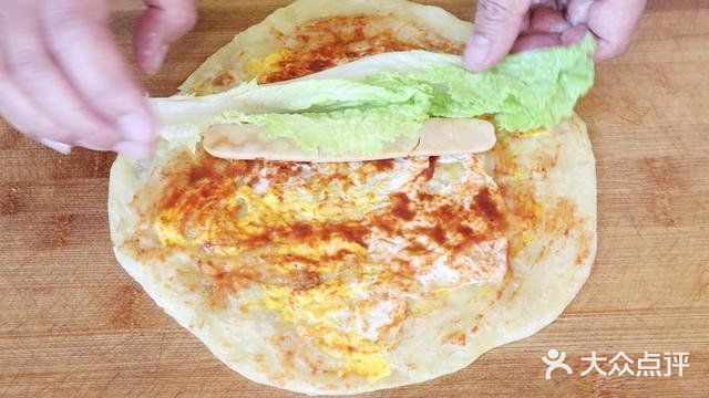 用手将饼皮摊平，盖锅焖上一分钟。一分钟后打开翻面