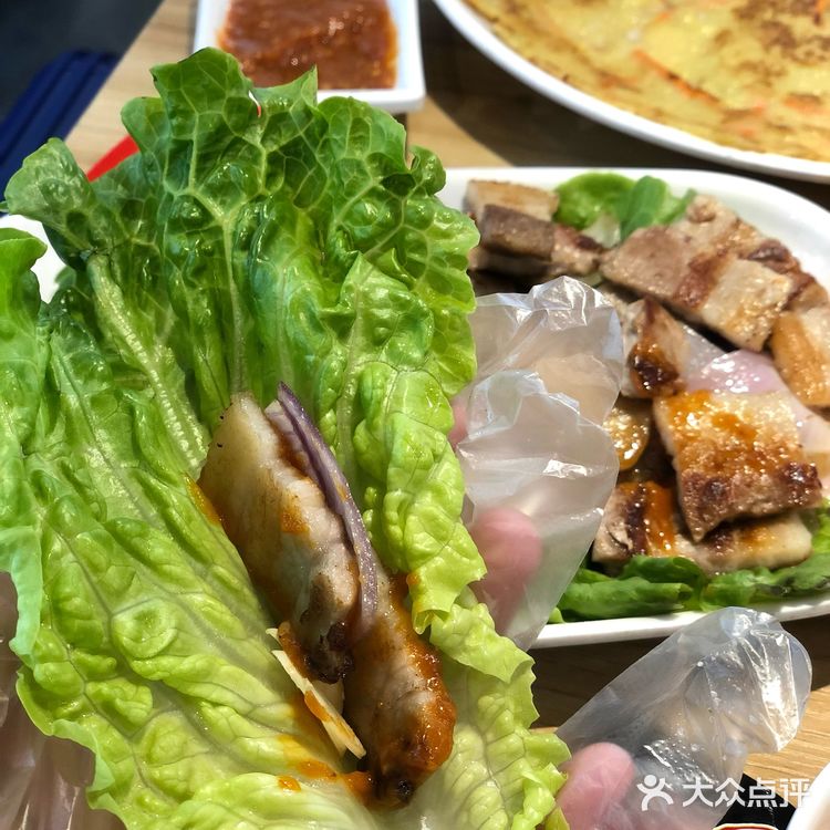 烤好的五花肉沾点酱汁，一定要配大蒜片了，完全吃不腻