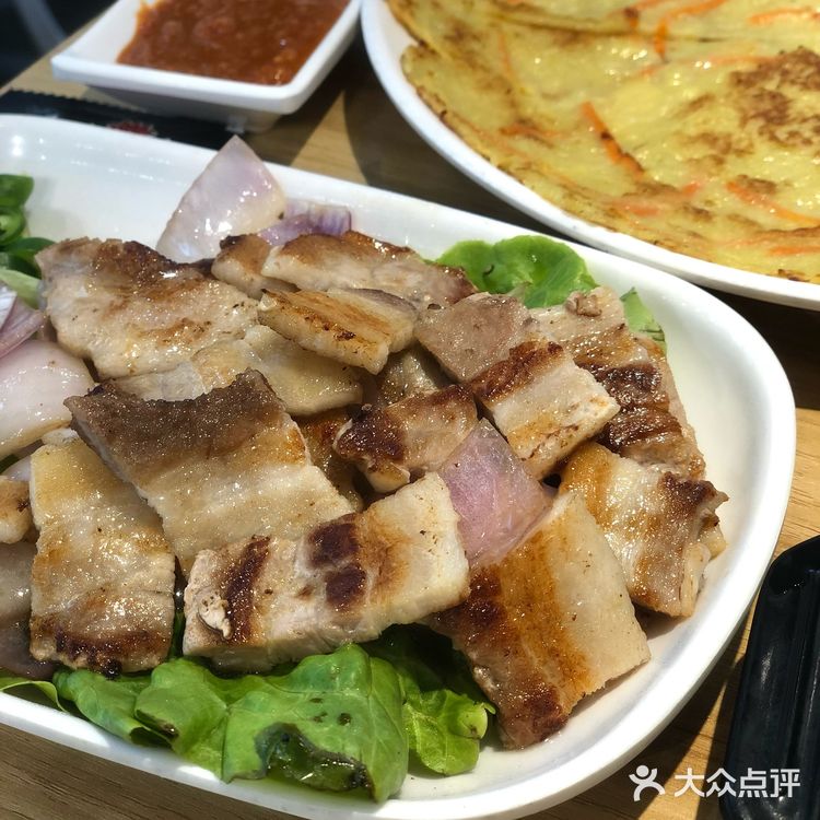 烤好的五花肉沾点酱汁，一定要配大蒜片了，完全吃不腻