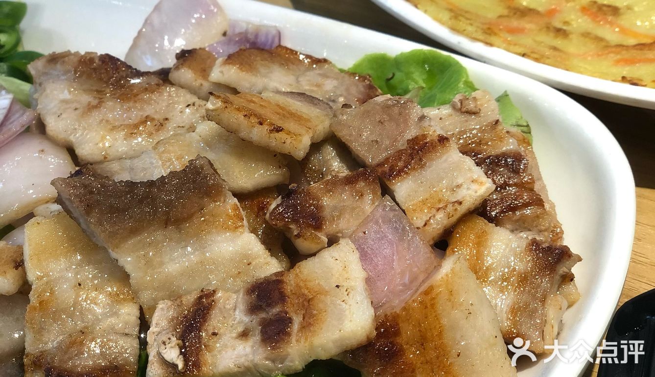 烤好的五花肉沾点酱汁，一定要配大蒜片了，完全吃不腻