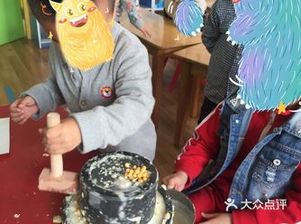 小伙子在老师的指导下认识了磨豆浆的工具——磨
