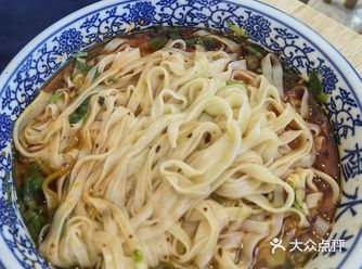 店内环境朴实无华，木质桌椅摆放整齐，墙上挂着兰州的老
