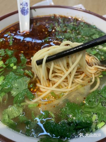 手工拉出的面泼上秘制辣子和小葱之后