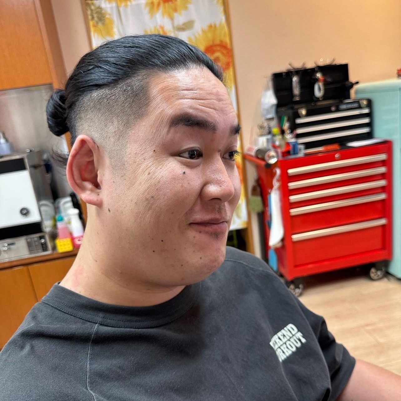 它源自于古代日本武士的发型设计,通常是留长顶部并梳成髻,两侧则修剪