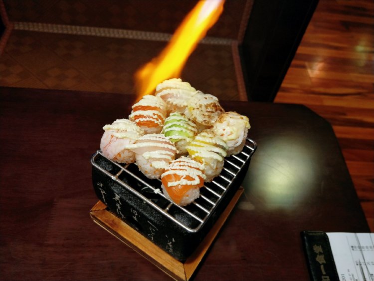 这是由师傅现场用火焰喷枪炙烤的特色菜品.