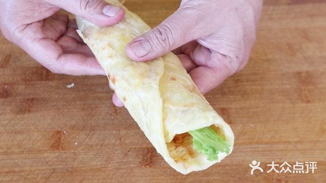 用手将饼皮摊平，盖锅焖上一分钟。一分钟后打开翻面