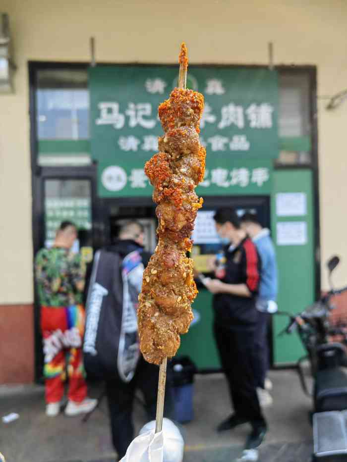 就在马路东南边十字路口,外卖窗口卖电烤串,里边是超市,有些传统食品