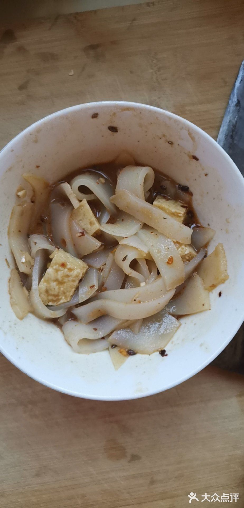 将凉皮锅放到锅中的开水上,慢慢将凉皮锅中的汤摇匀