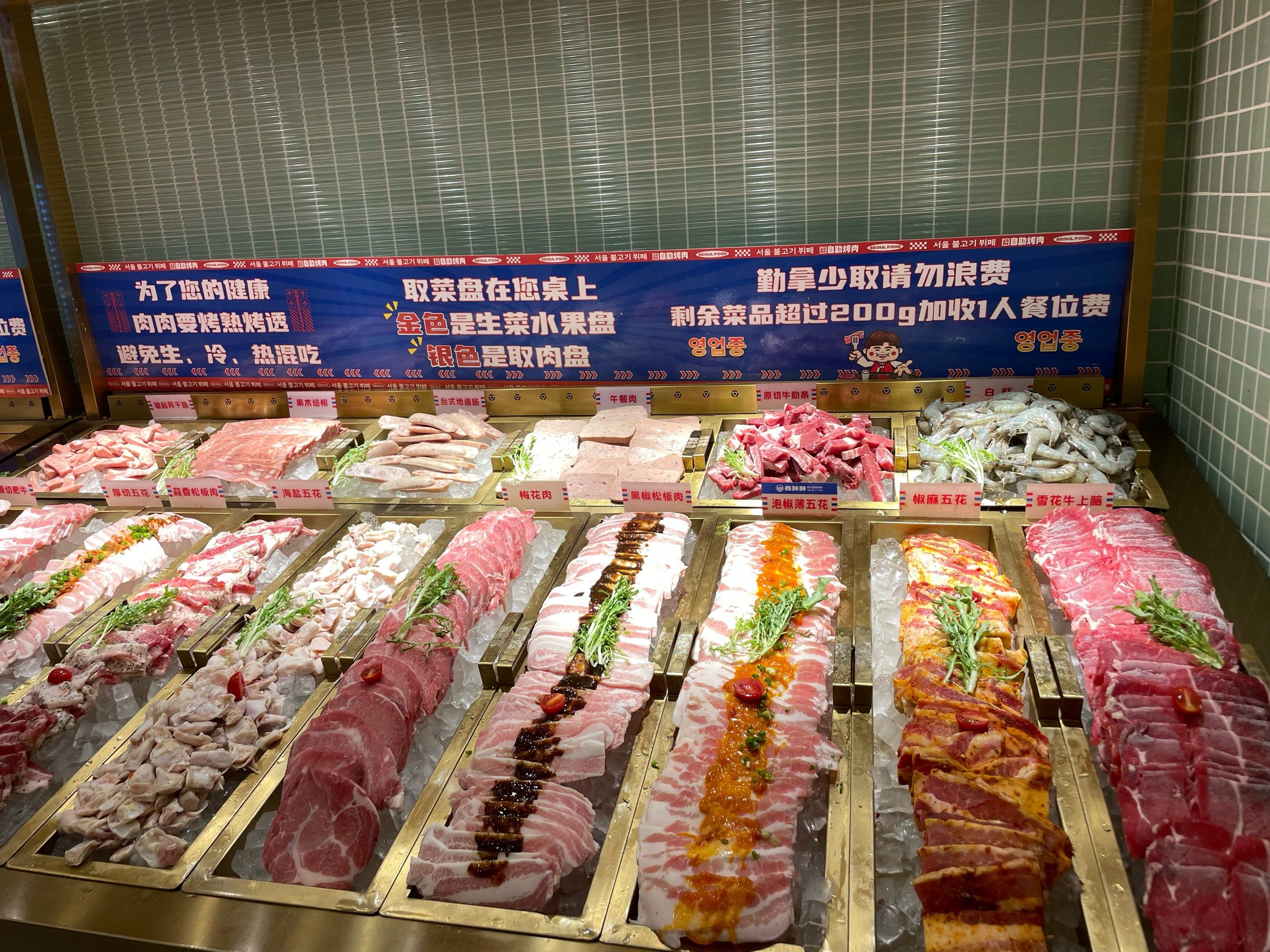 丰富的菜品陈列在餐台上,各种新鲜的肉类是烤