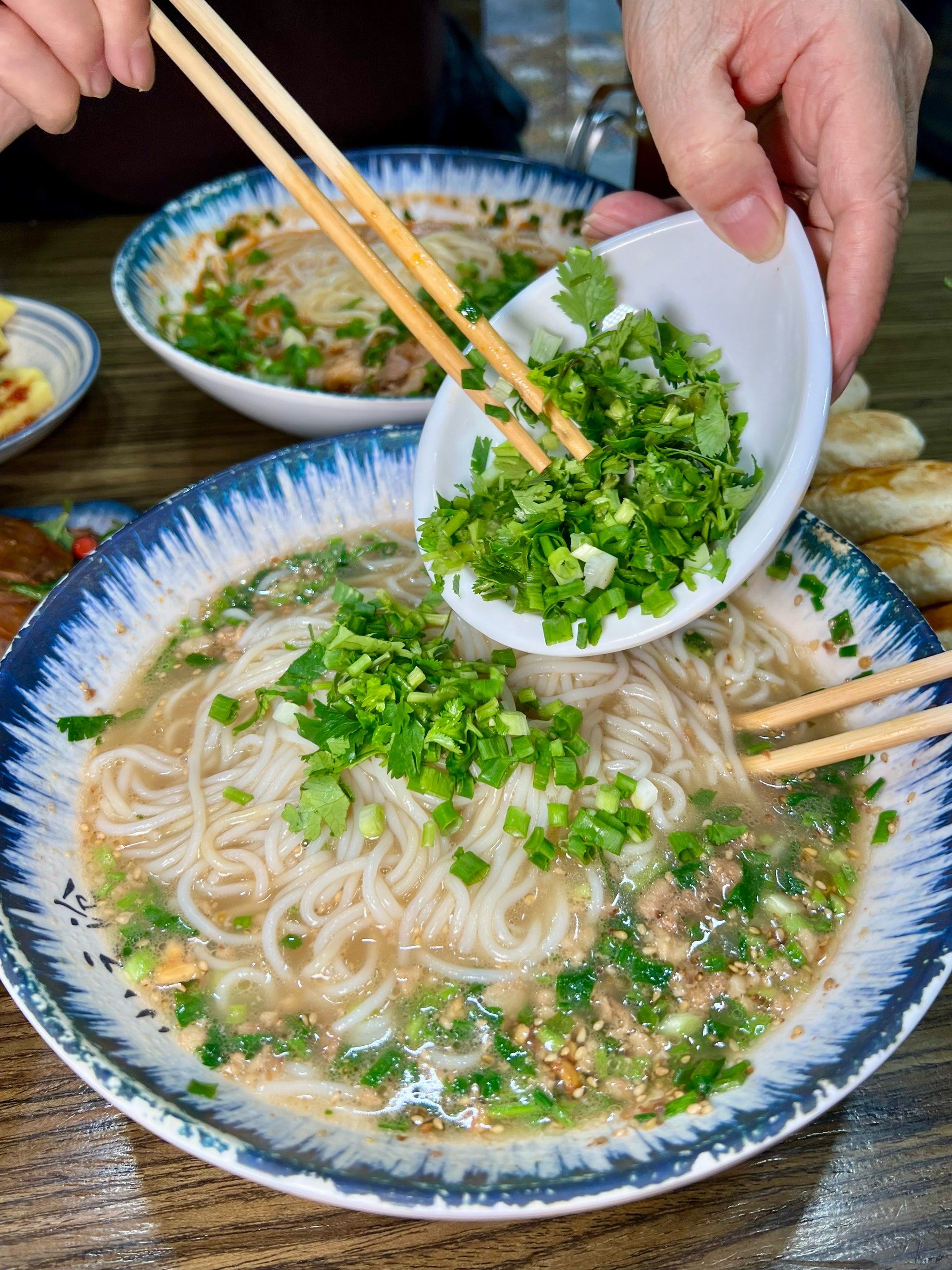 米线放在炉灶上煮熟
盛上骨汤 加入肉酱韭菜葱花等等小菜
制作的