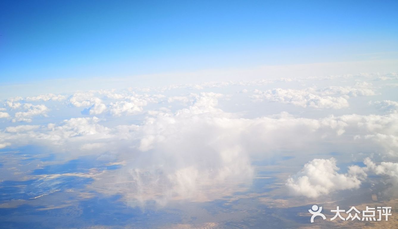 天空很蓝，几朵白云就像是画上去似的，天空和白云都很干净