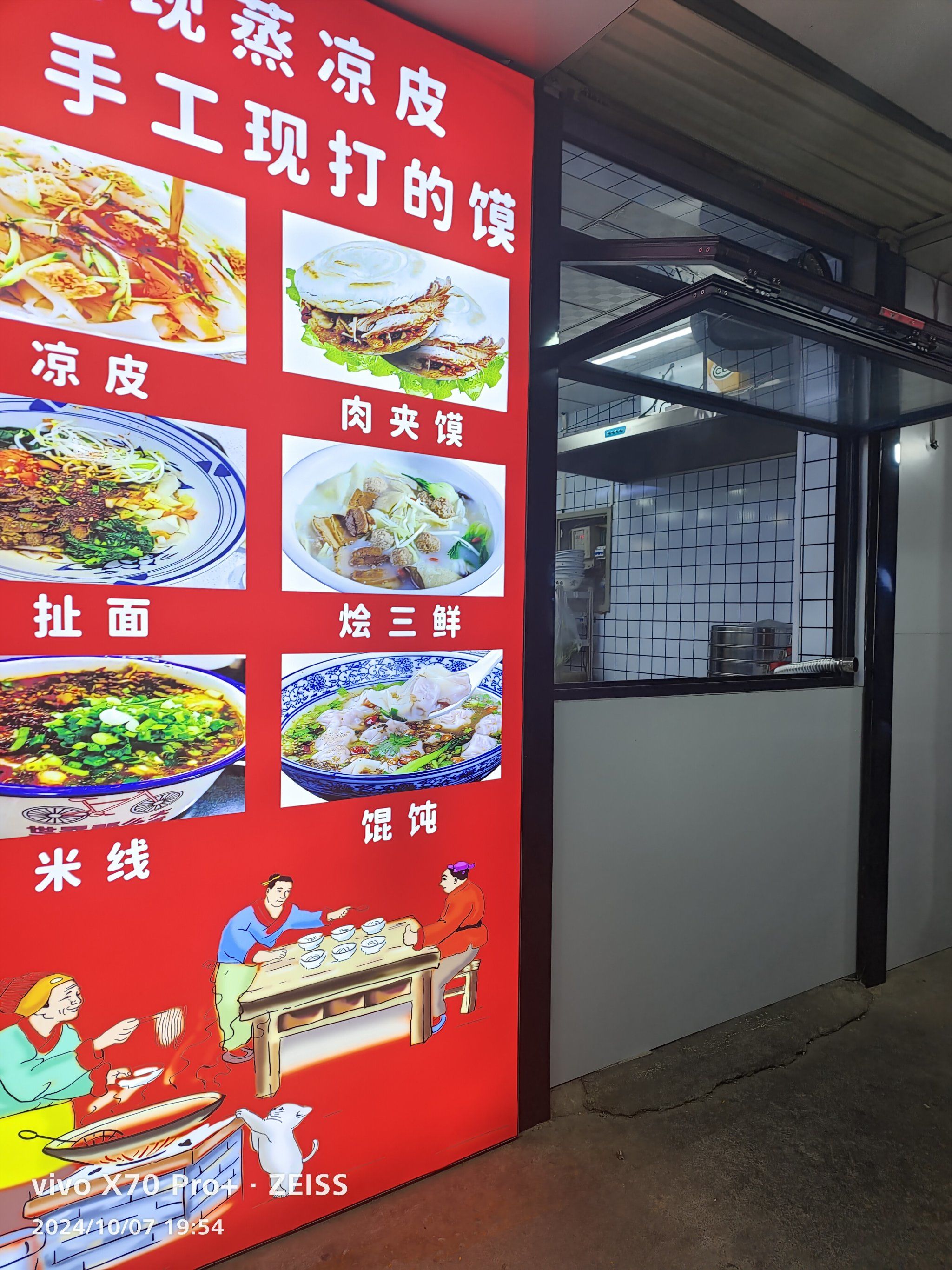 家肉夹馍店,门头是白底黑字很醒目,店里的饼是现打的,凉皮也是现蒸的