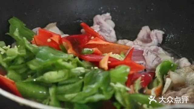 瘦肉炒变色后再放入切好的辣椒和大蒜头继续翻炒