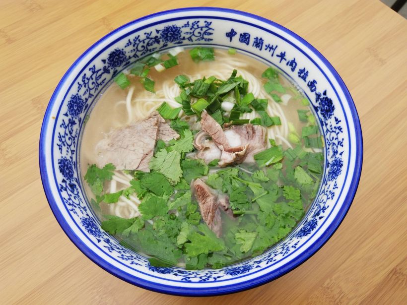 有点青花瓷感觉的碗装起这个牛肉清汤面,撒上葱花和香菜,你别说还很