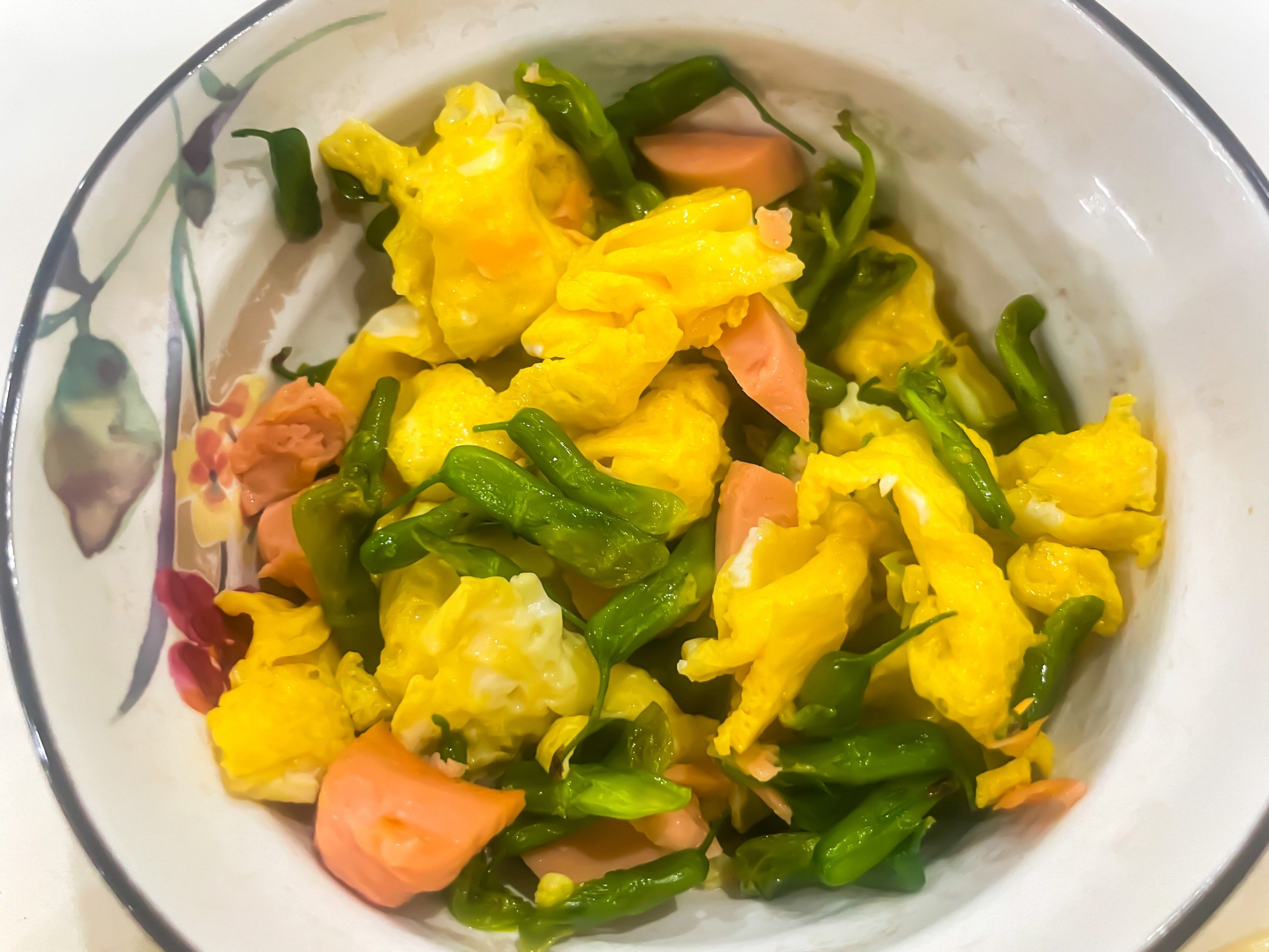下鸡蛋翻炒半熟捞出,炒火腿肠和金雀花,加入鸡蛋,加一点盐,翻炒均匀出