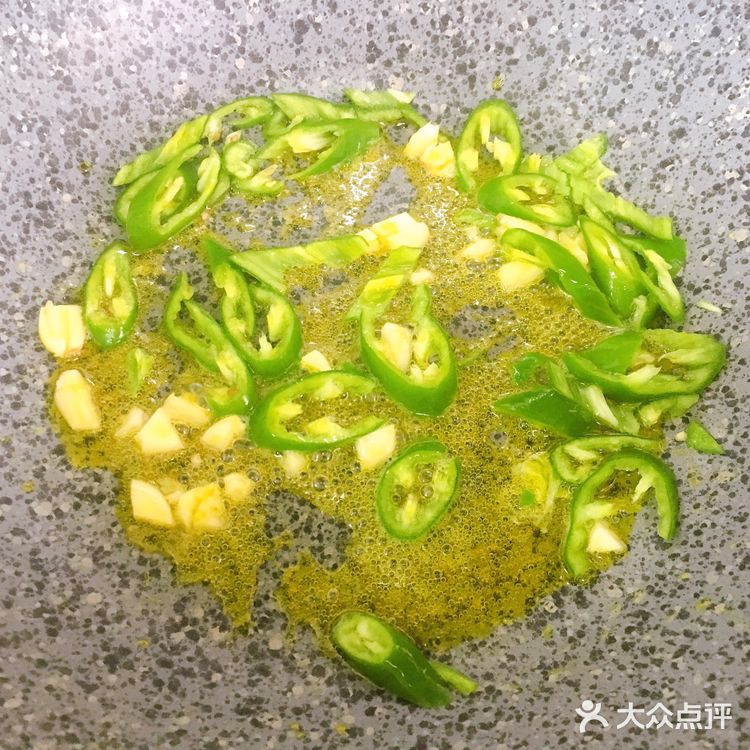 再放入青椒，炒出辣味，接着倒入毛豆，翻炒均匀
