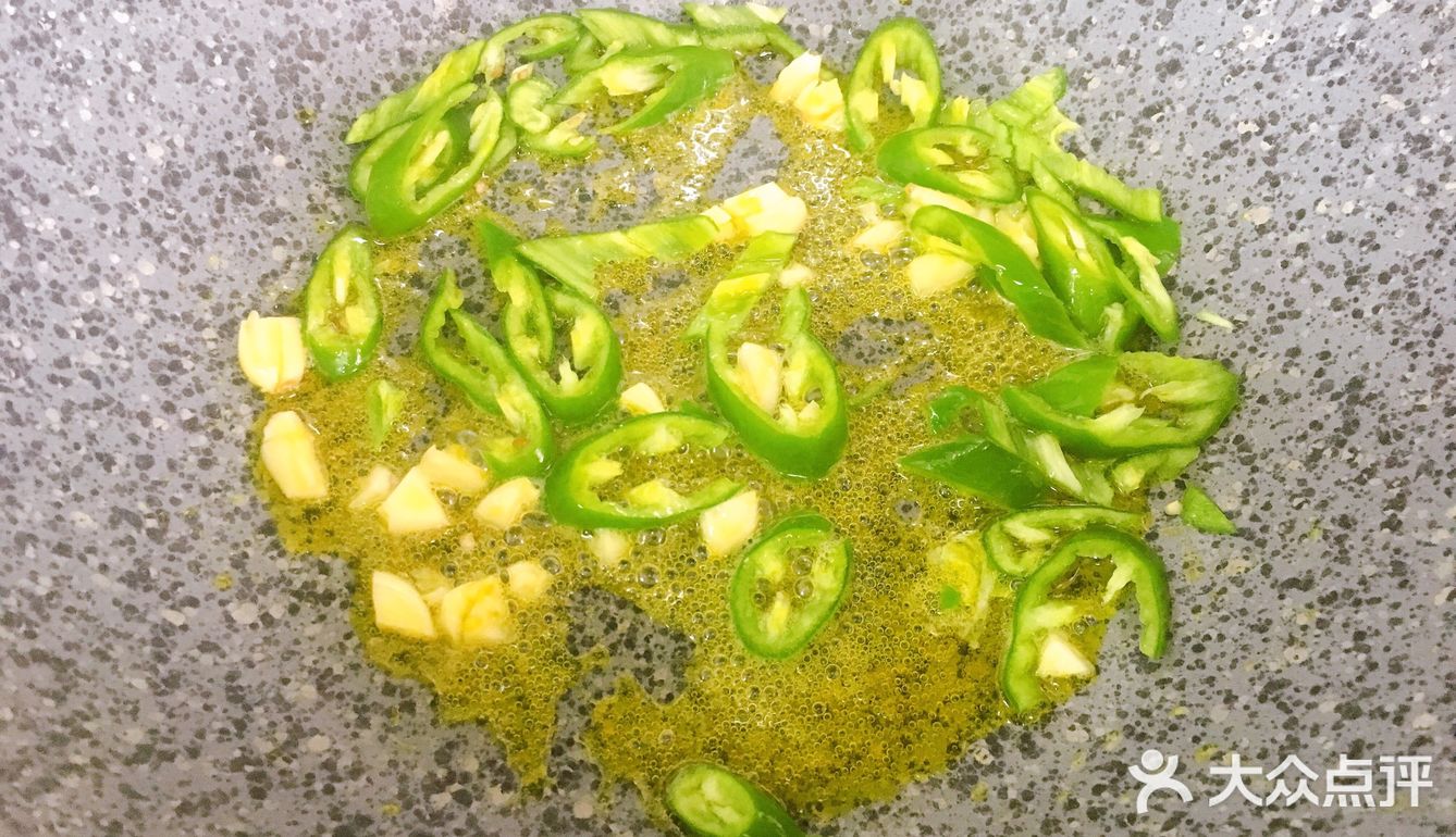 再放入青椒，炒出辣味，接着倒入毛豆，翻炒均匀