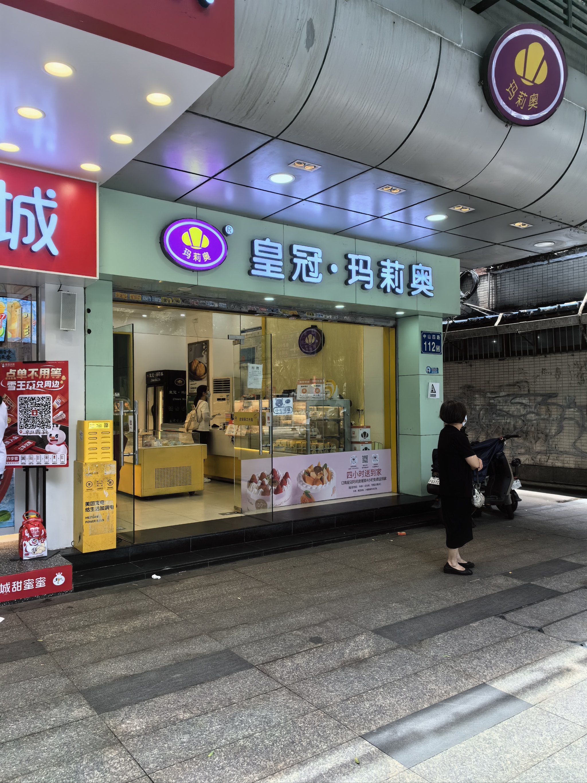 [微笑]烘焙面包连锁店,玻璃陈列柜内摆满各式面包酥点,灯光照射下光润