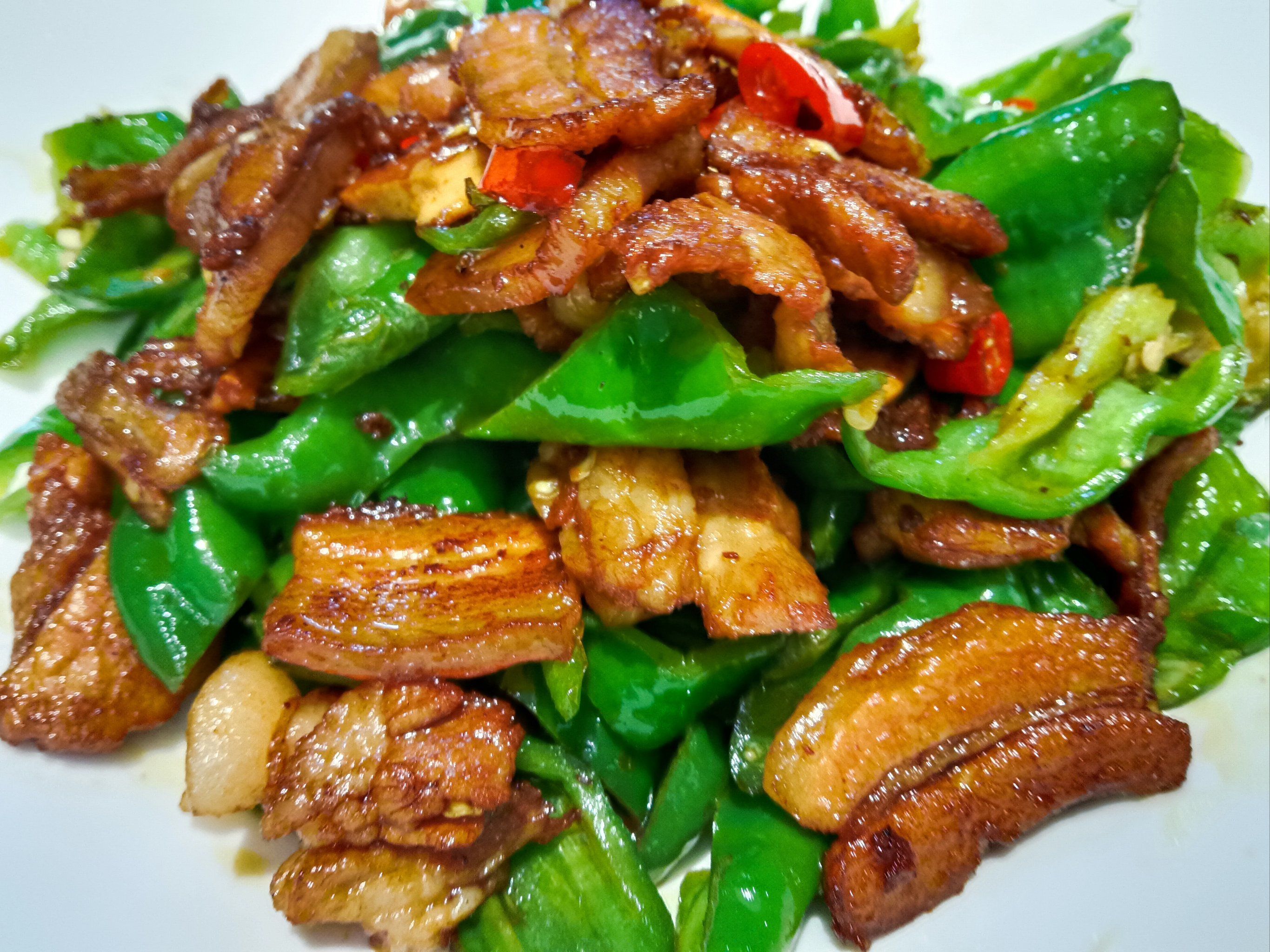 五花肉经过煸炒,油脂渗出,香气四溢,青椒