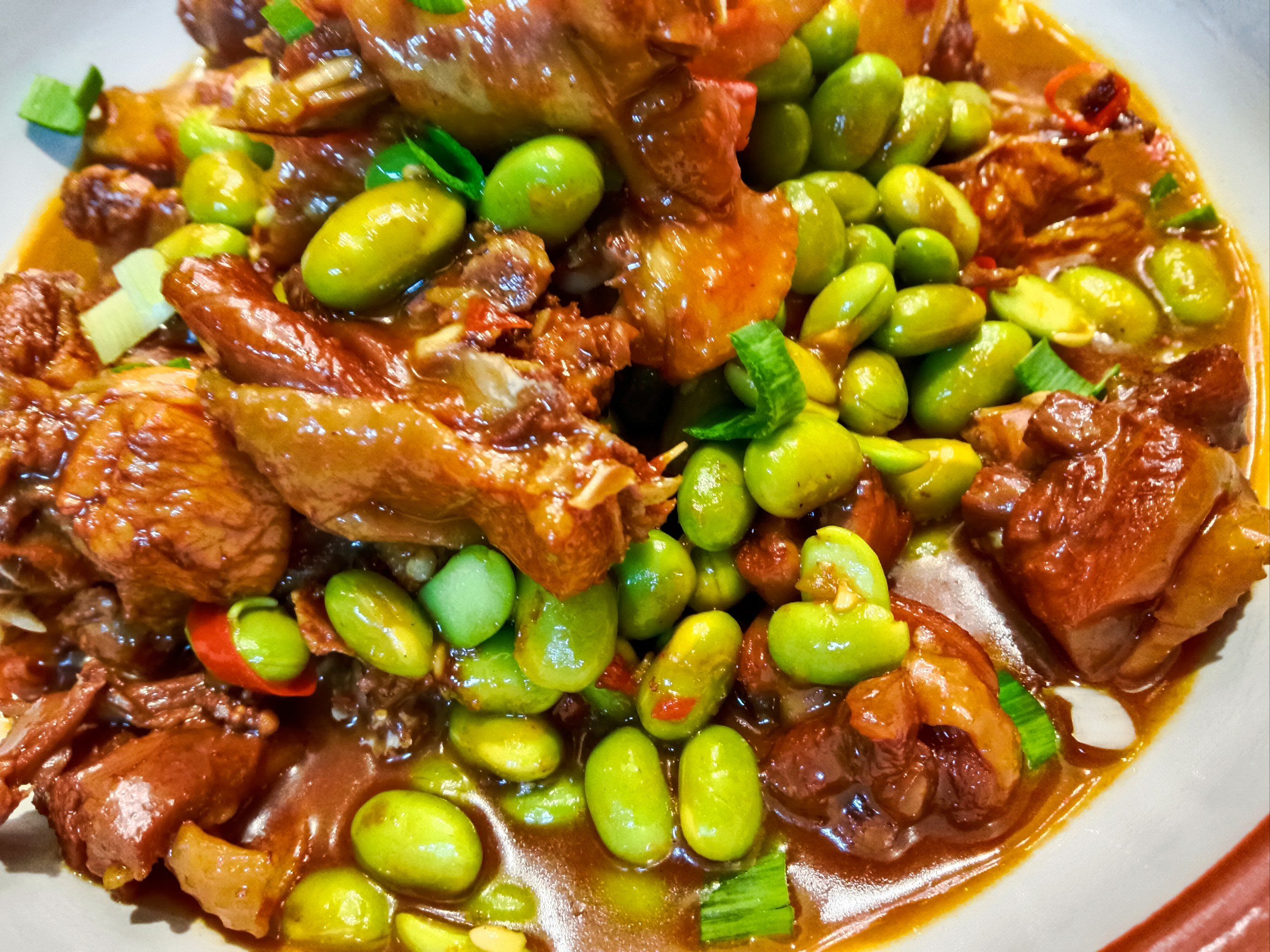 毛豆烧鸡堪称美味佳肴.鲜嫩的鸡肉在锅中炖