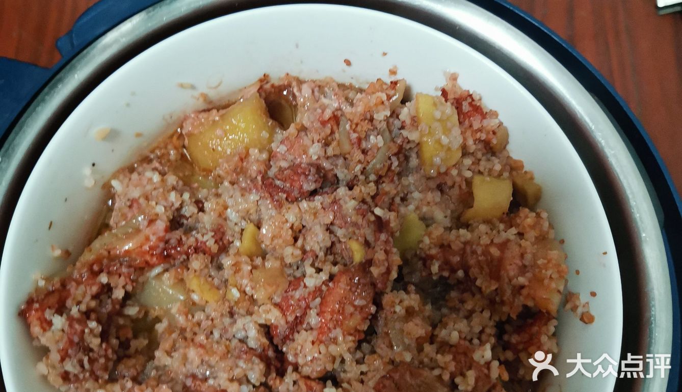 在把调好的土豆和肉架上，锅盖好，按下蒸肉按钮