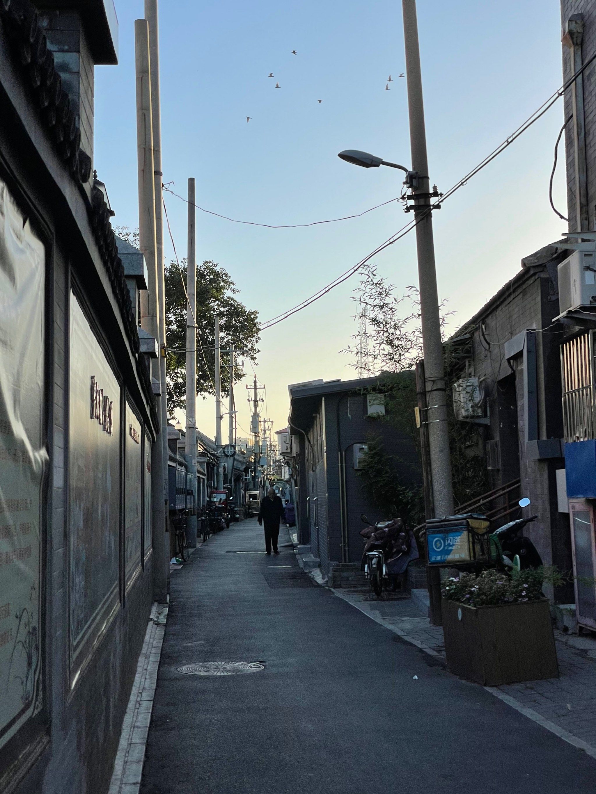 路过一个胡同口,一边是市井生活,一边是高楼大厦