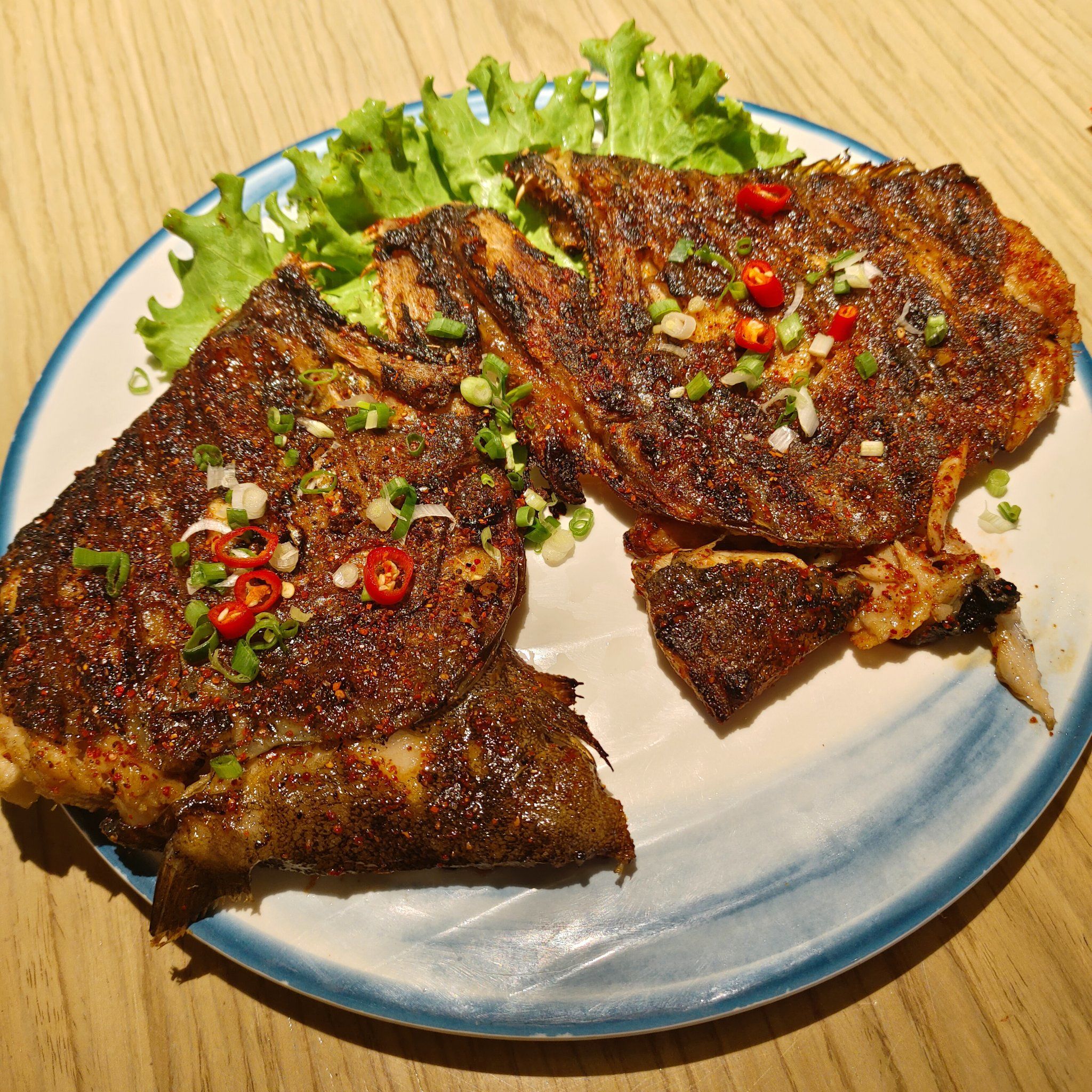 炭烤的过程中,碟鱼头的表面会形成一层香脆的外壳,内部则保持着多汁的