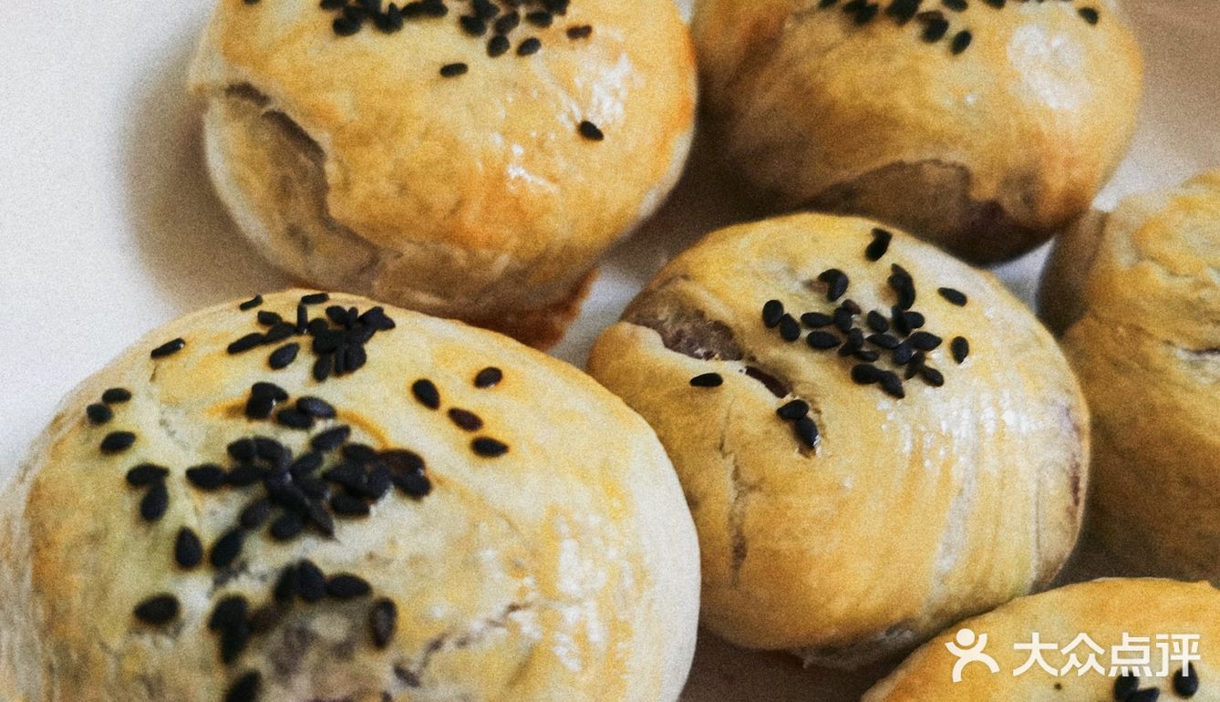 手抓饼分5块卷入香肠，涂上蛋黄液和黑芝麻