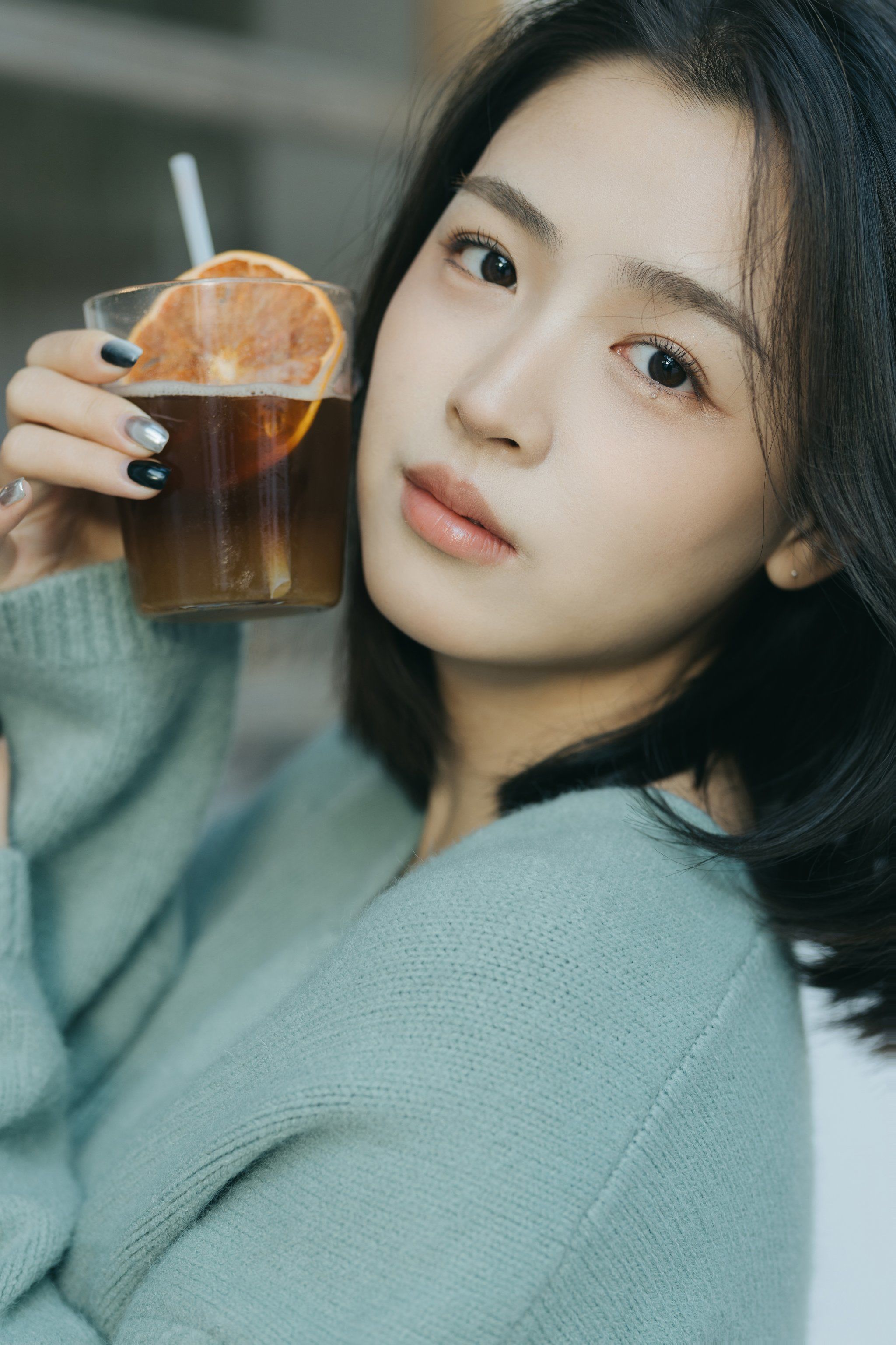 女孩静静的坐在咖啡店的小角落里望着窗外的车水马龙