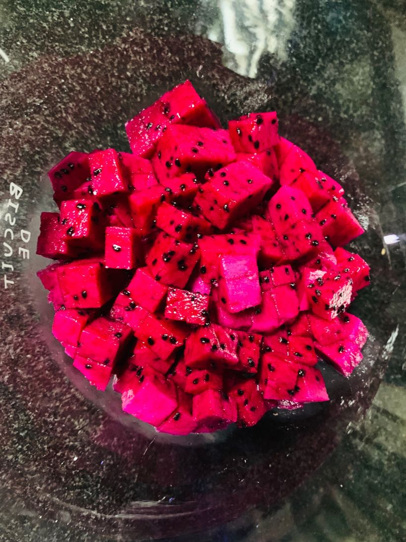 哈密瓜切开,去籽,切小颗粒铺红心火龙果上面.