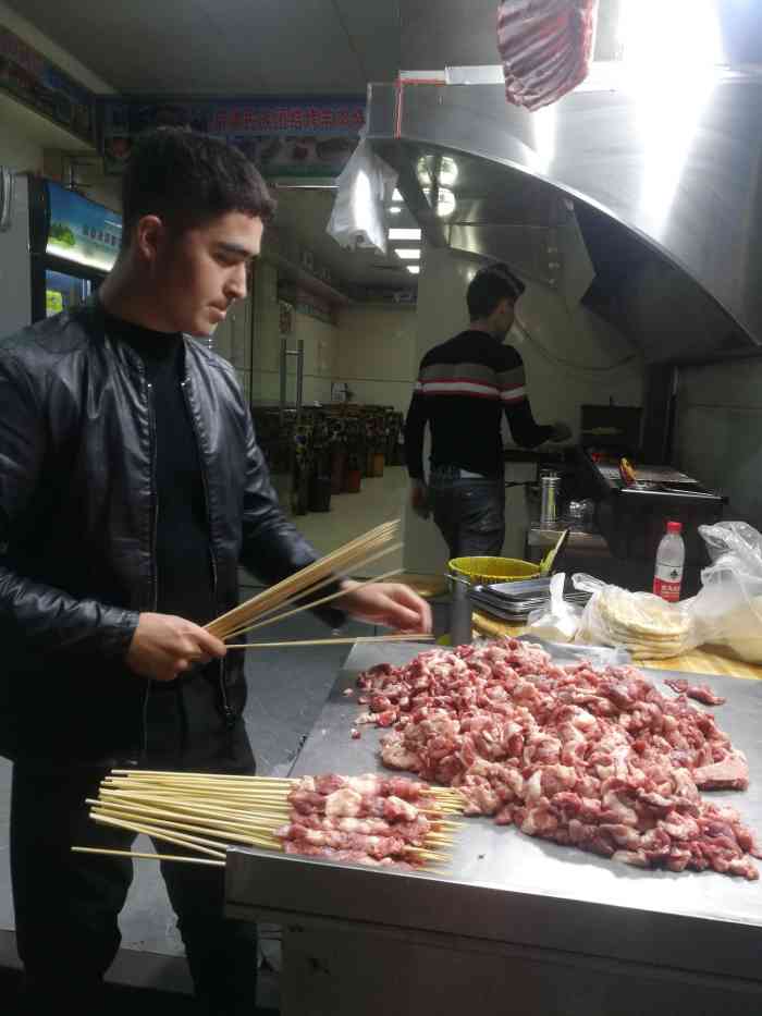新疆民族团结烤羊肉店"路边这家烧烤店,老板在路边支起烤架烤羊肉.