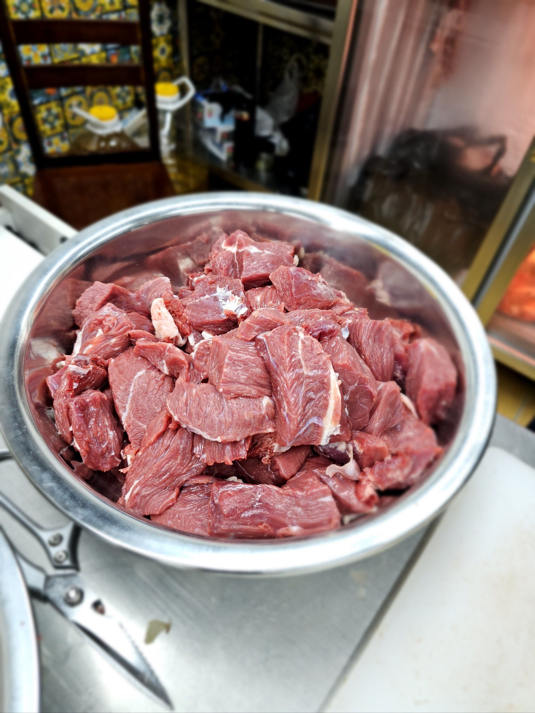 服务员正在切肉,一盆一盆的牛肉块儿,看着很新鲜