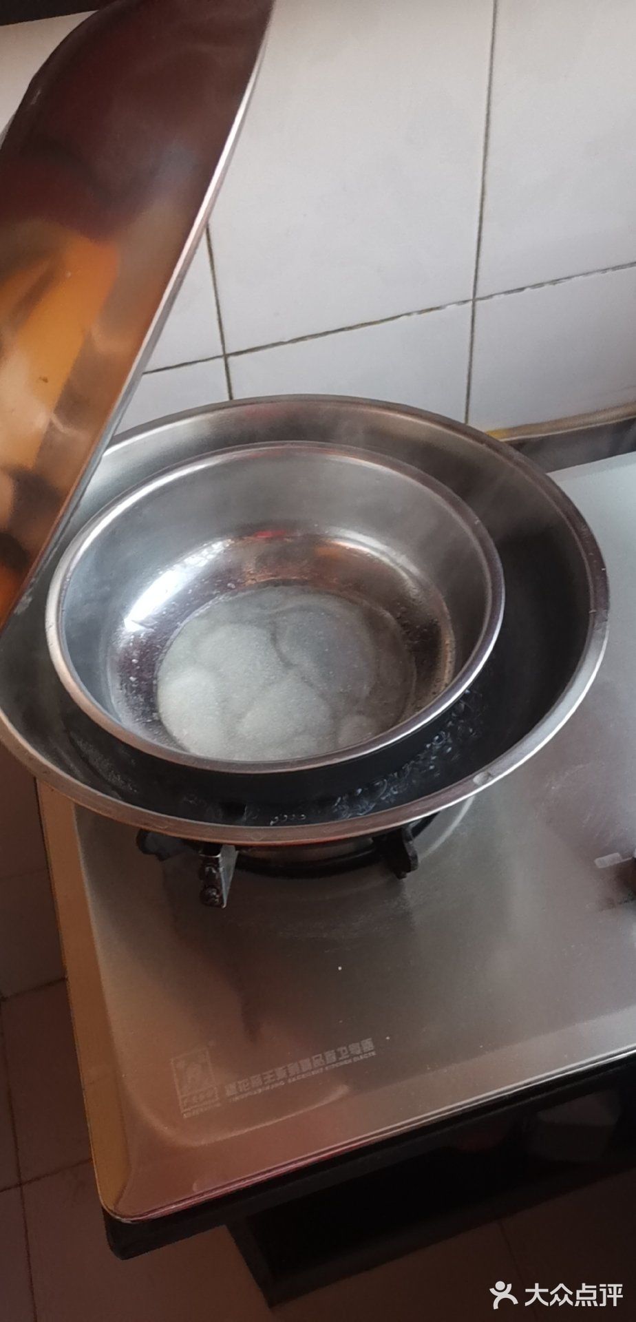 将凉皮锅放到锅中的开水上,慢慢将凉皮锅中的汤摇匀